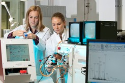 Mit dem Massenspektrometer können Forscher viele Proteine auf einmal identifizieren. Das Gerät entnimmt die zu untersuchenden Zellen automatisch aus dem Probenbehälter links im Bild). Die Peptid-Fragmente werden in einer Glassäule aufgetrennt und mittels Elektrospry ioniziert (Mitte). Rechts im Bild sind die Signale der Peptide zu sehen.